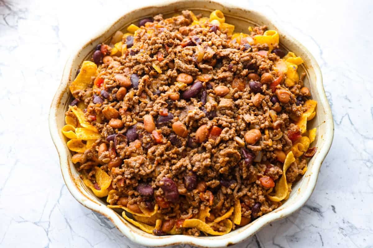 Chili layered on top of the Fritos in the pie pan.