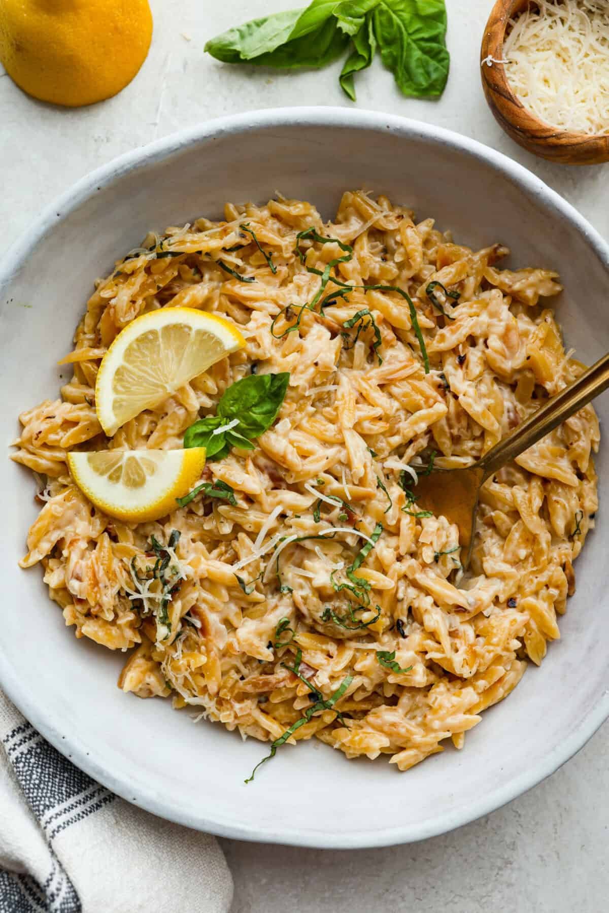 Fresh lemons make me so happy! They’re bright, cheerful, and lift me out of the winter rut. Add that citrusy sunshine to a creamy pasta, and you get this dreamy Creamy Lemon Orzo! Simple, rich, and bursting with feel-good flavor. Overhead shot of plated creamy lemon orzo.