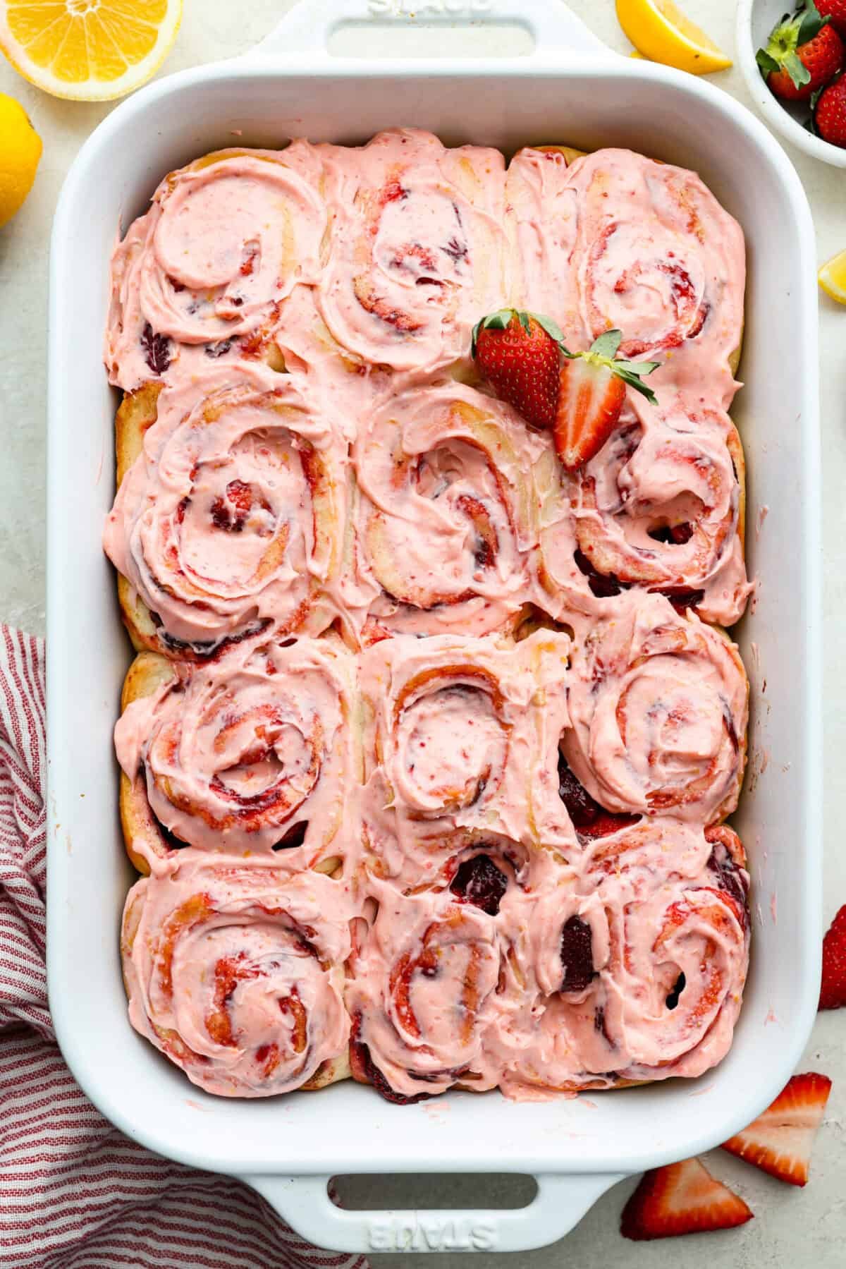 Strawberry cinnamon rolls are going to become a tradition in your house after you make these! The secret is the freeze-dried strawberries mixed with the lemon zest in the glaze - the flavor is to die for! Overhead shot of strawberry cinnamon rolls in a baking dish.