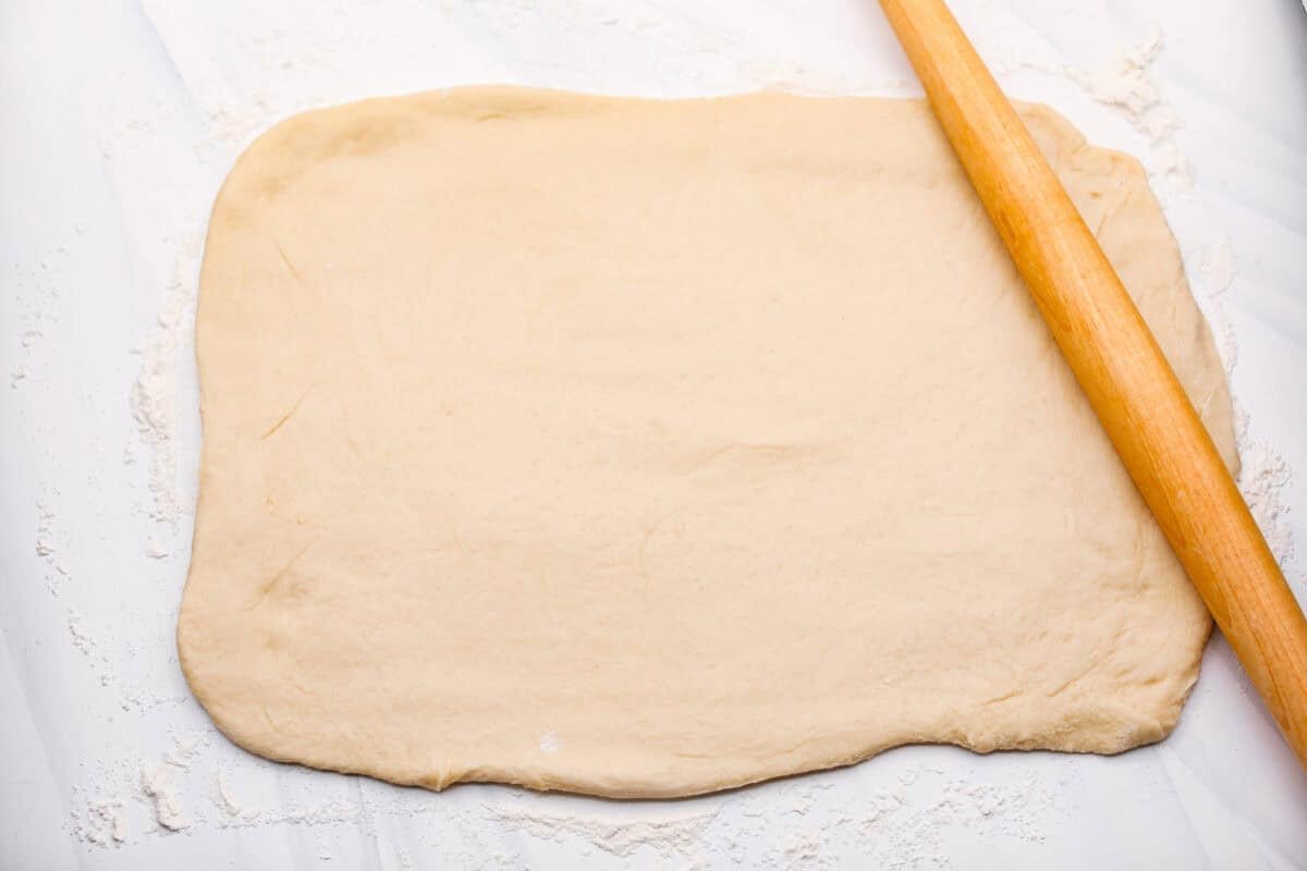 Strawberry cinnamon rolls are going to become a tradition in your house after you make these! The secret is the freeze-dried strawberries mixed with the lemon zest in the glaze - the flavor is to die for! Overhead shot of the dough rolled out onto a floured surface.