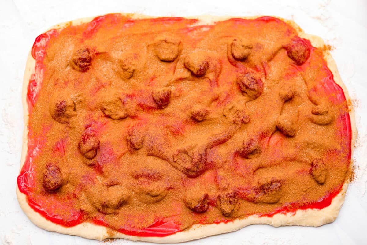 Strawberry cinnamon rolls are going to become a tradition in your house after you make these! The secret is the freeze-dried strawberries mixed with the lemon zest in the glaze - the flavor is to die for! Cinnamon and sugar mixture sprinkled over the top of the strawberry pie filling that is spread on the dough.