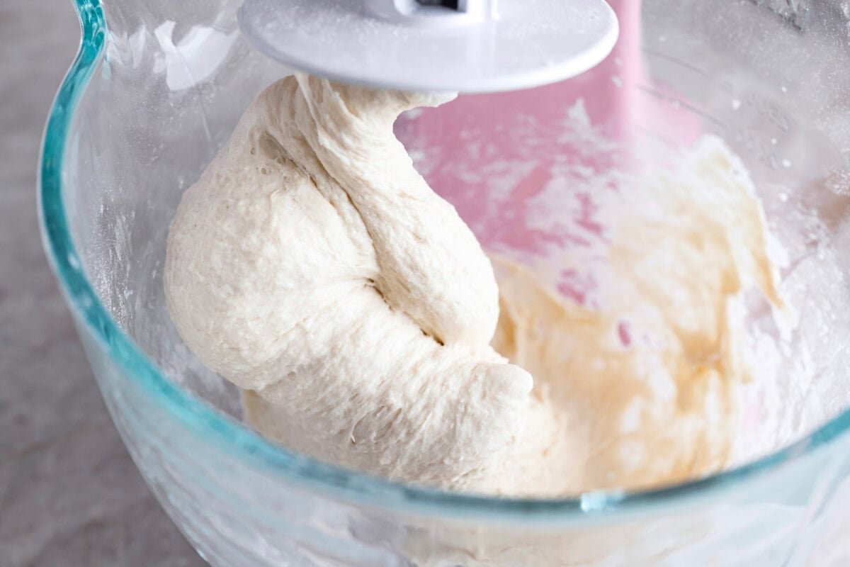 Pizza Hut breadsticks are warm, fluffy, and buttery, but this copycat recipe is even better! Coated in seasoning, parmesan, and melted butter, they’re next-level delicious. Dough being mixed with a stand mixer.