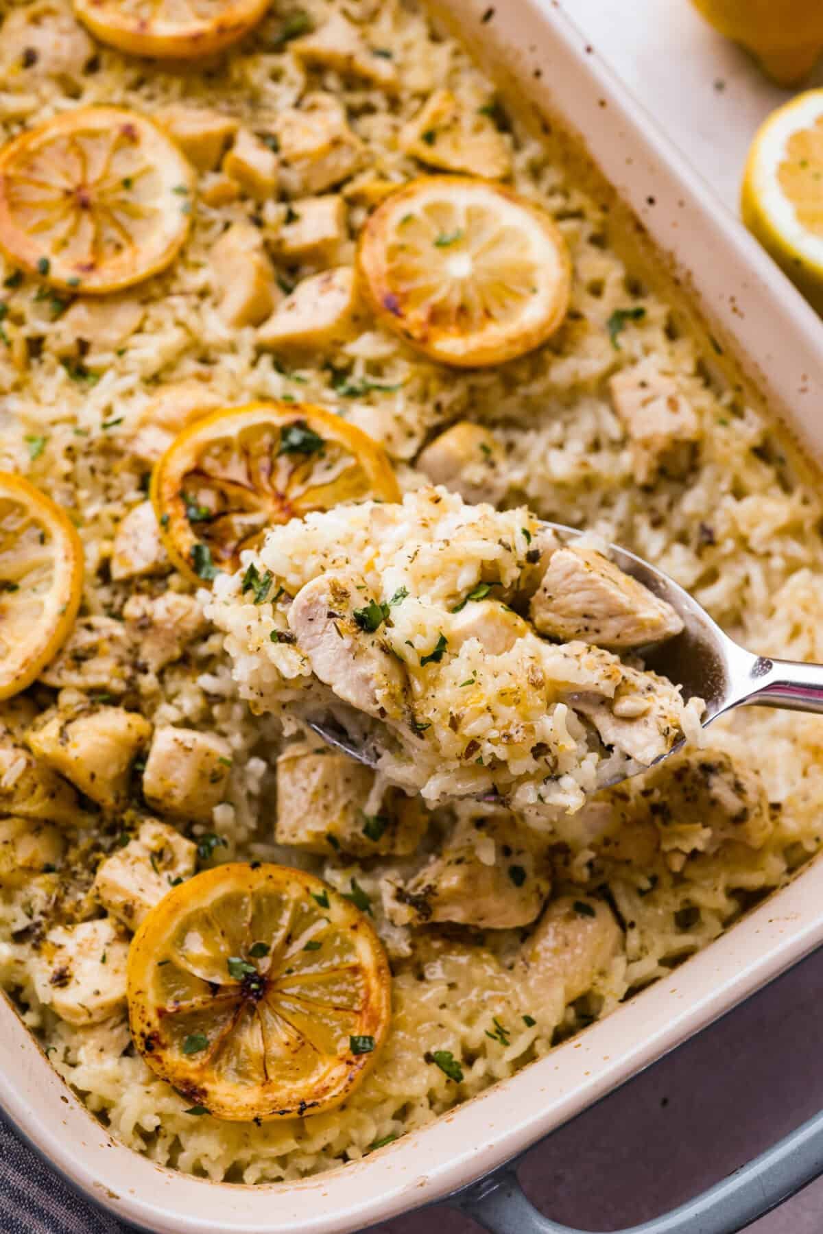 You guys love lemon chicken anything—and honestly, same. So I had to give you this lemon chicken casserole. With my signature made from scratch lemon herb sauce, you'll want this on repeat! Some on lifting a spoonful of lemon chicken casserole out of the dish.