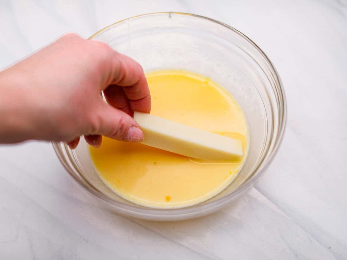 The secret to perfect mozzarella sticks comes down to three key steps: using the right mozzarella, double breading for a sturdy crust, and fully freezing them before frying. I’ve broken down these expert tips below! Someone dipping a cheese stick into the egg mixture.