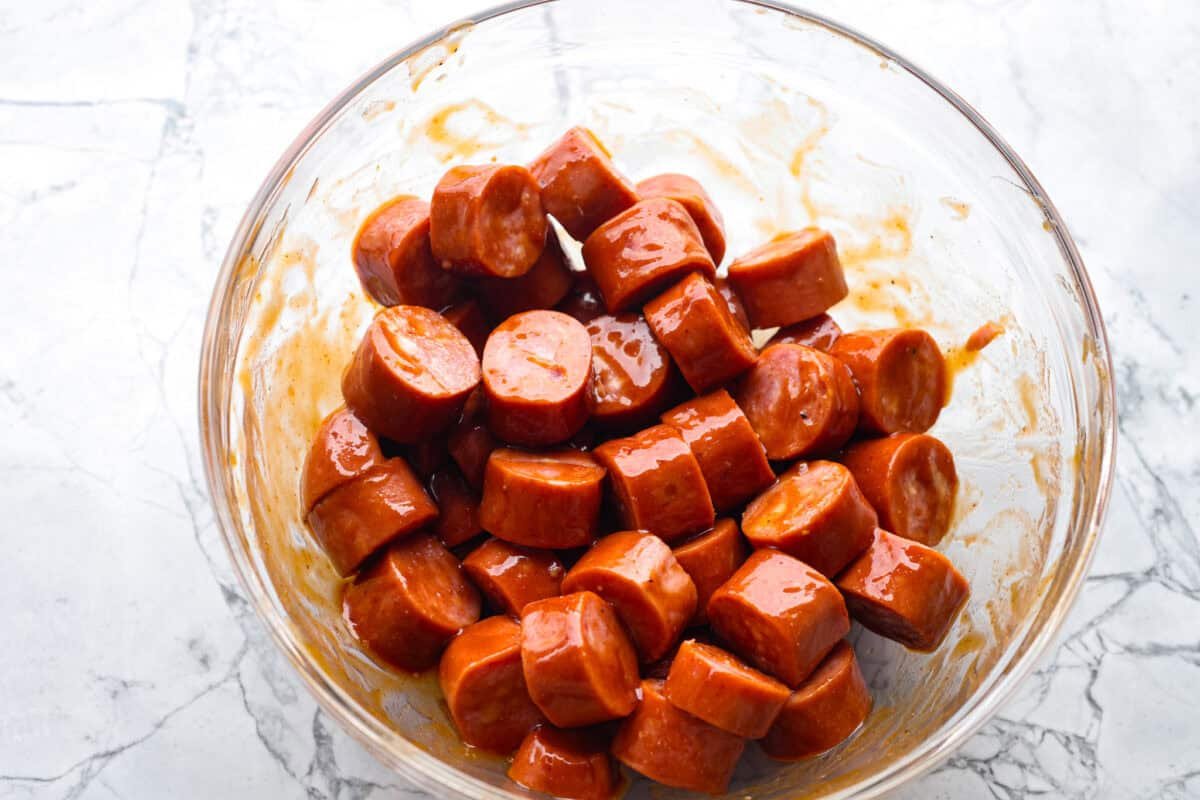 Kielbasa Bites are the ultimate crowd-pleasing appetizer! With their smoky, savory flavor and caramelized glaze sweetness, these bite-sized snacks are easy to make and always a hit at parties, game days, or anytime you need a quick appetizer! Overhead shot of sausage bites mixed with the glaze.