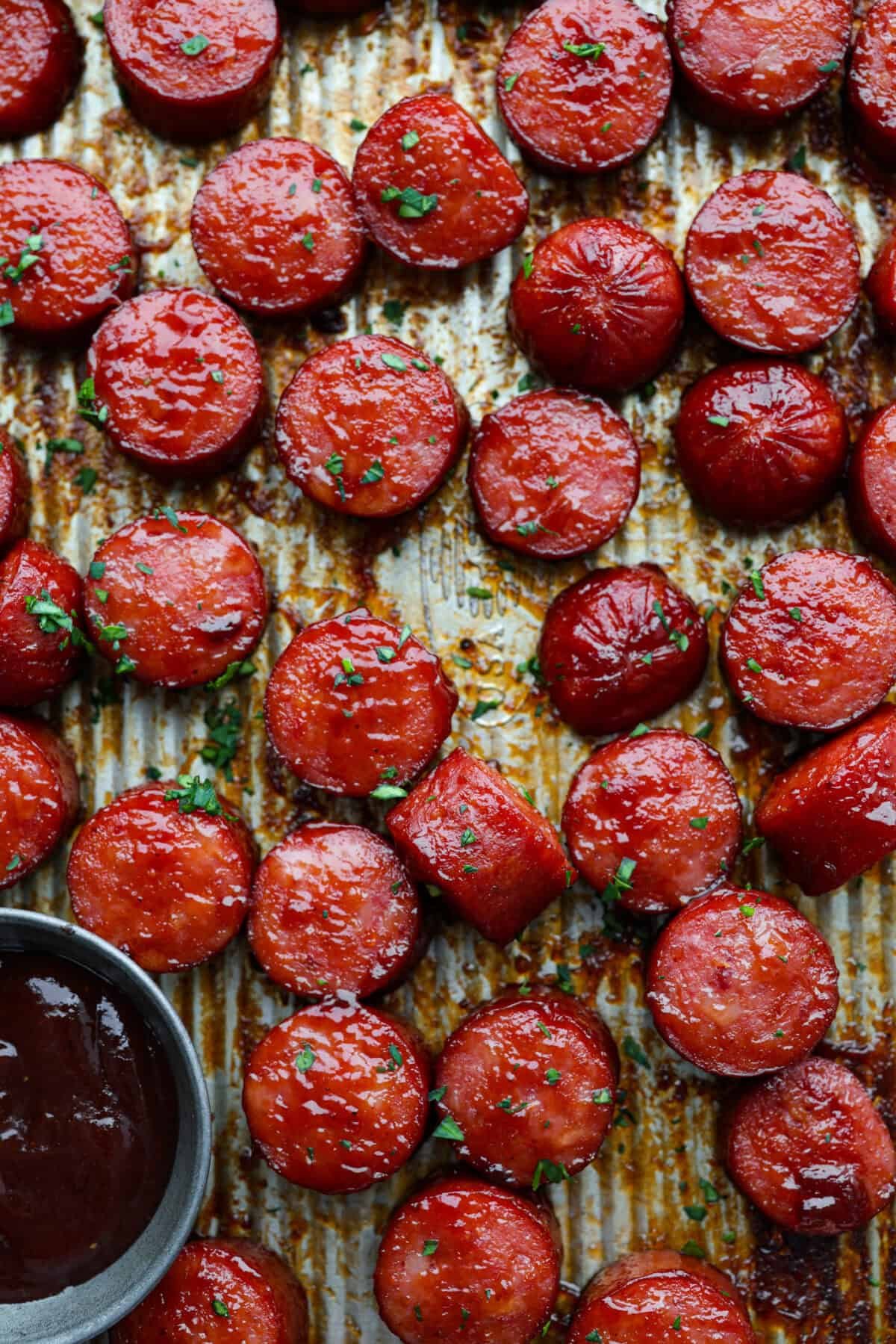 Kielbasa Bites are the ultimate crowd-pleasing appetizer! With their smoky, savory flavor and caramelized glaze sweetness, these bite-sized snacks are easy to make and always a hit at parties, game days, or anytime you need a quick appetizer! Close up shot of cooked kielbasa.