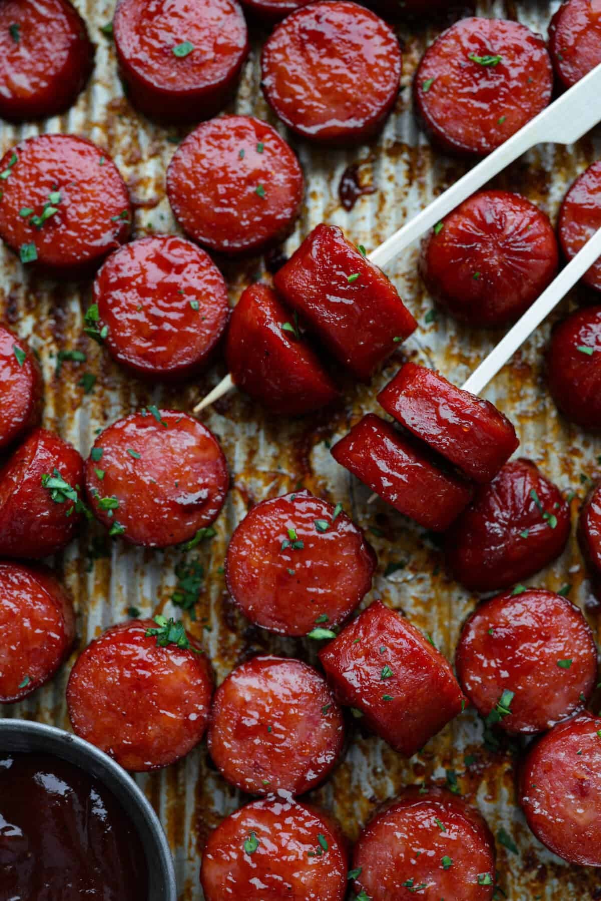 Kielbasa Bites are the ultimate crowd-pleasing appetizer! With their smoky, savory flavor and caramelized glaze sweetness, these bite-sized snacks are easy to make and always a hit at parties, game days, or anytime you need a quick appetizer! Overhead shot of kielbasa bites on toothpicks.