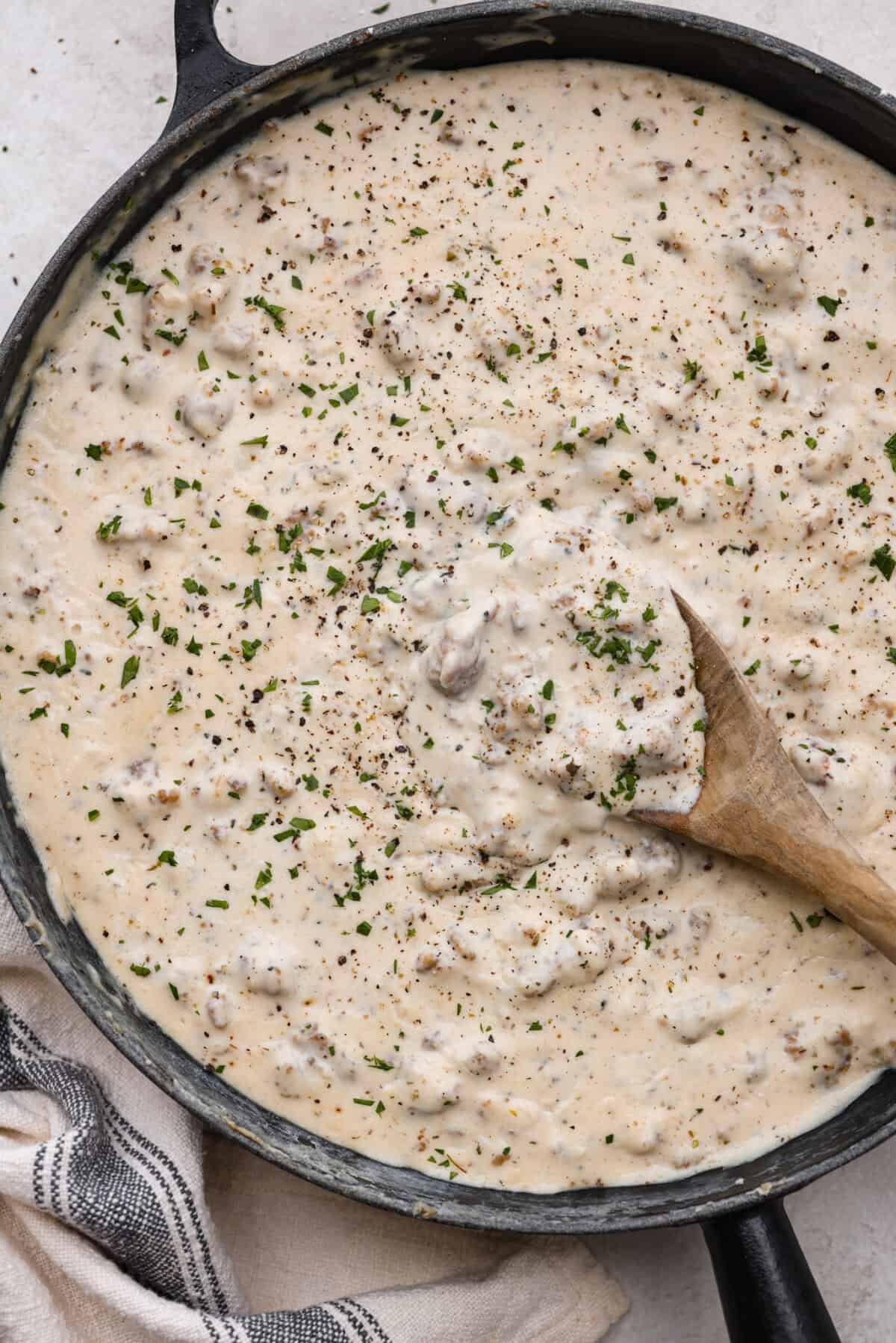 Homemade sausage gravy is perfect for a comforting breakfast! In just 15 minutes and with a few simple ingredients, you’ll have a delicious, hearty gravy to top fluffy biscuits. Overhead shot of sausage gravy in a large skillet.