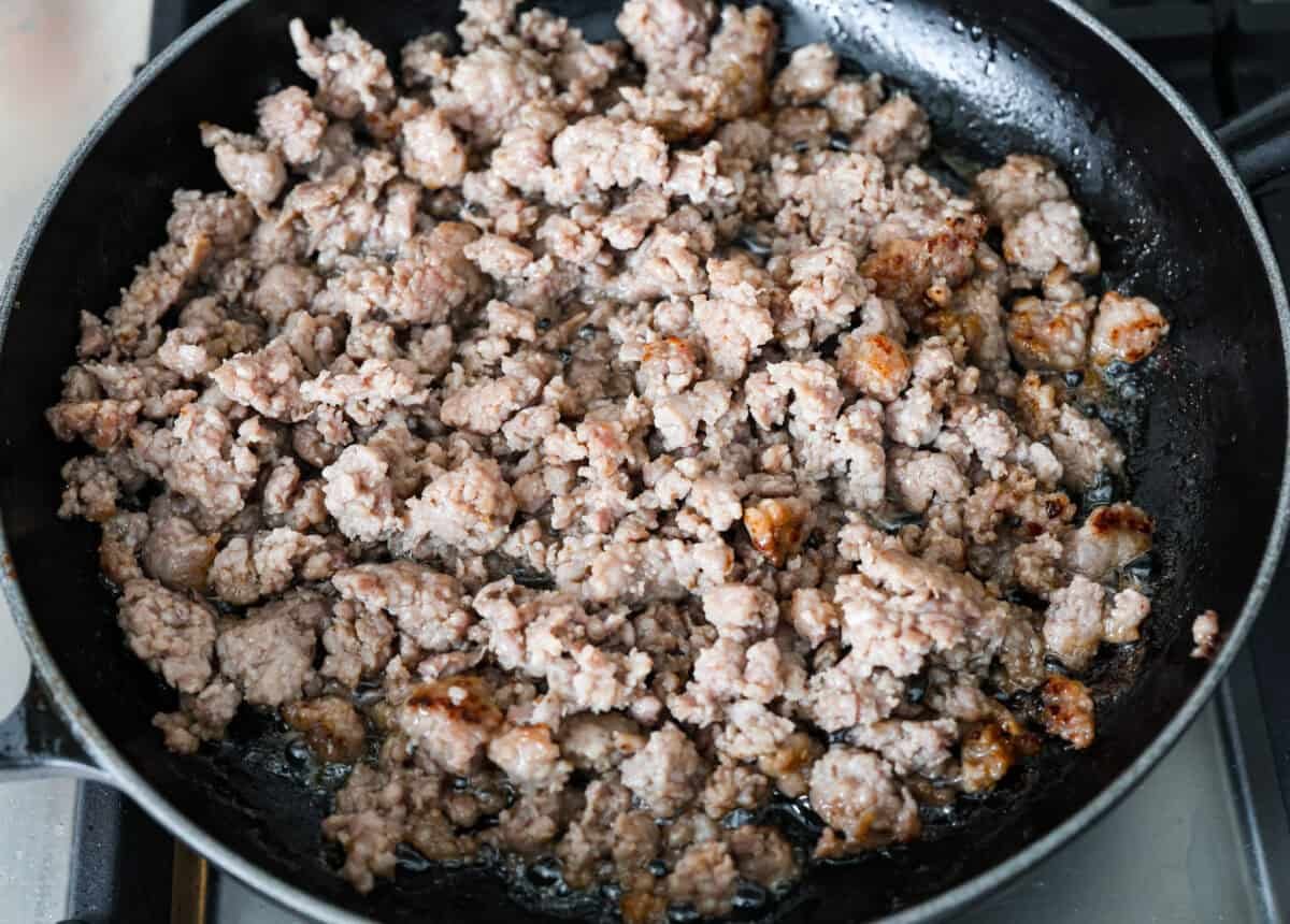 Homemade sausage gravy is perfect for a comforting breakfast! In just 15 minutes and with a few simple ingredients, you’ll have a delicious, hearty gravy to top fluffy biscuits. Overhead shot of sausage cooking in a pan.