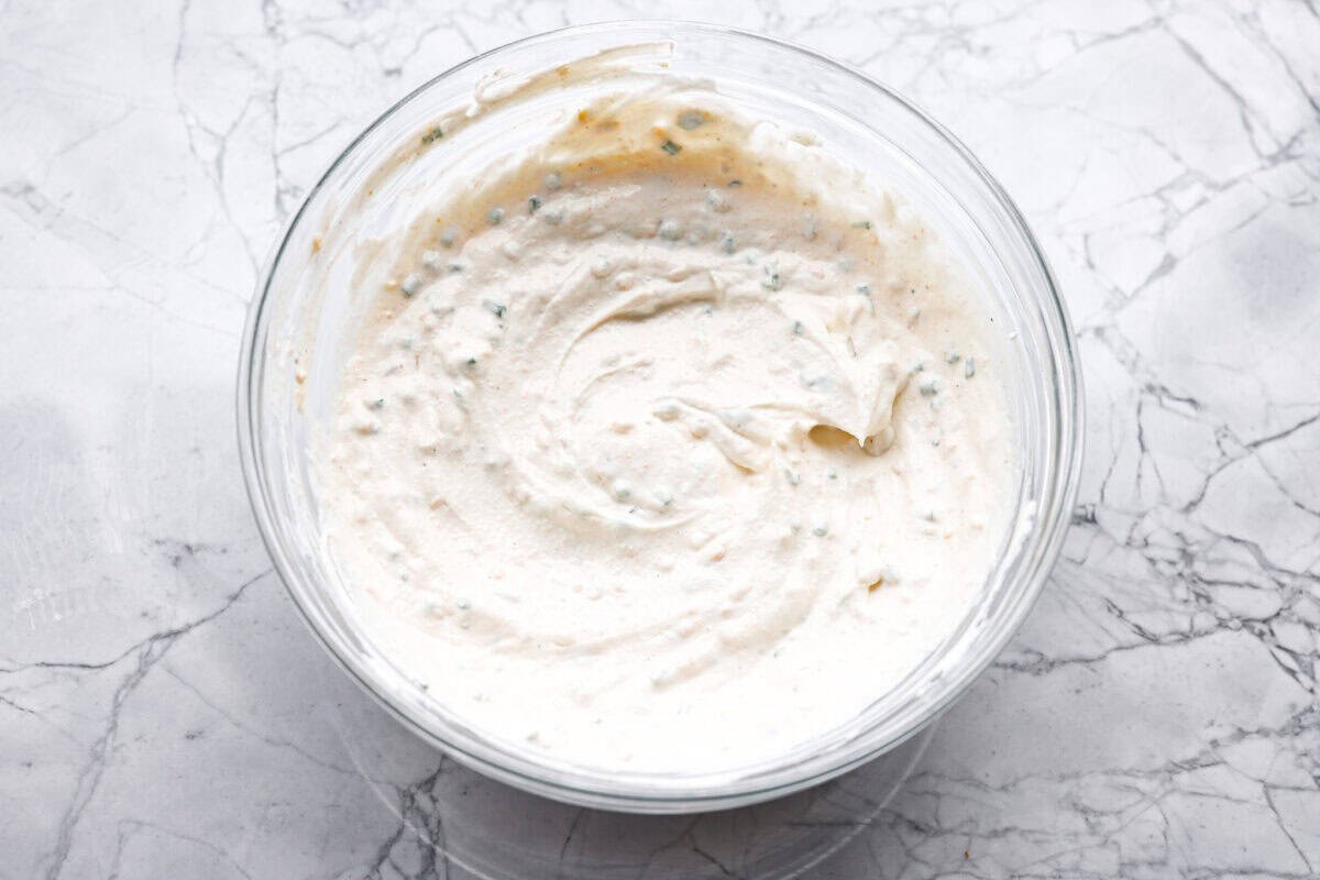 This sour cream and onion dip has become a staple at all of our family get togethers. It's the perfect appetizer, even the kids cant get enough! The rich and creamy dip is packed with incredible onion flavor. Overhead shot of all of the ingredients mixed together in a bowl.