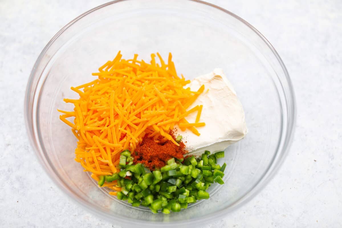 https://www.target.com/p/excalibur-seasoning-smokehouse-bbq-rub-seasoning-6oz-shaker-bottle/-/A-93218011#lnk=sametab Overhead shot of cheddar cheese, cream cheese, jalapeño, and bbq rub seasoning in a bowl.