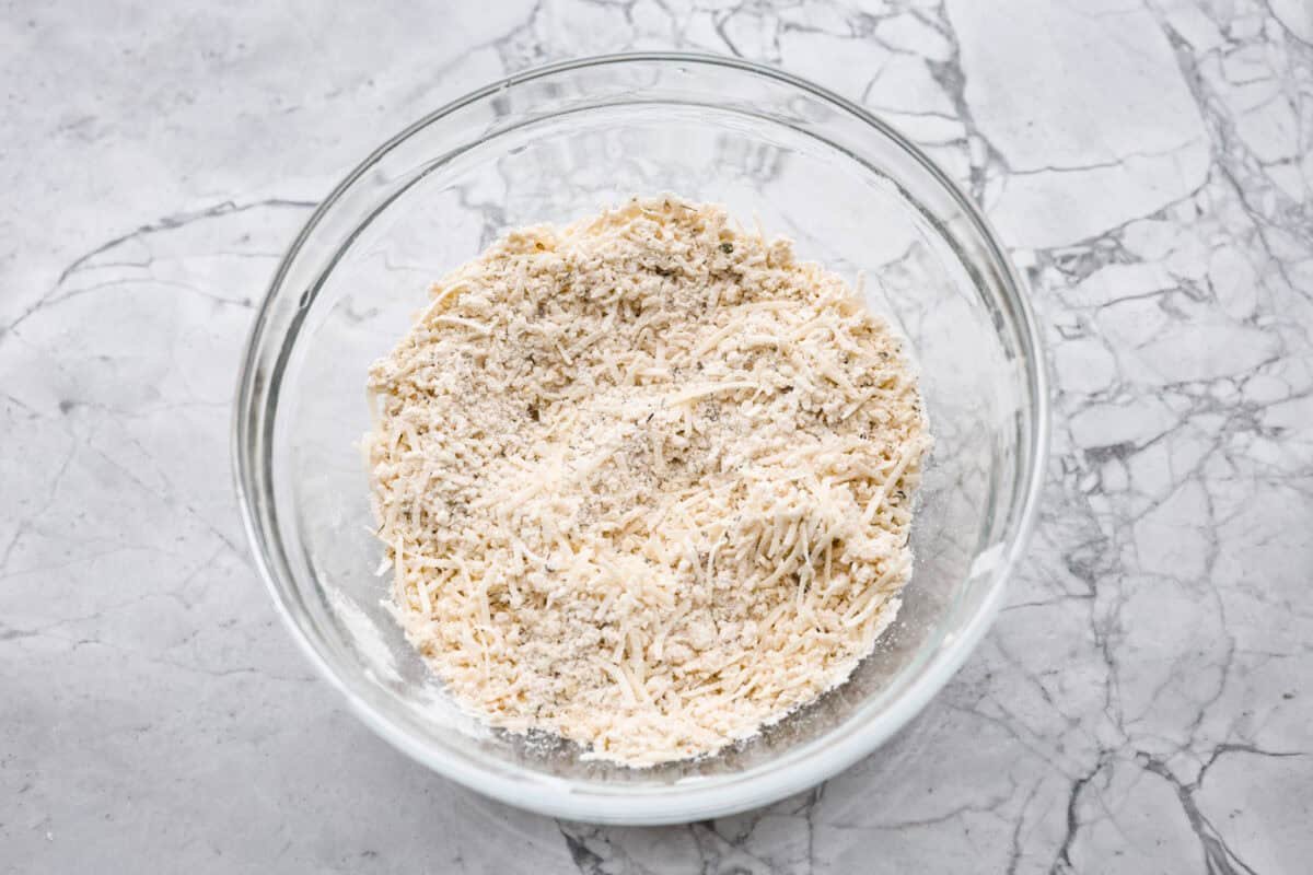 Crispy Air Fryer Eggplant is a fun flavor snack that is a healthier option than typical fried snacks. Tender eggplant slices are coated in crispy breadcrumbs and parmesan cheese, deliciously seasoned, then air-fried to perfection. Overhead shot of breadcrumbs, parmesan cheese, and seasonings mixed in a bowl.