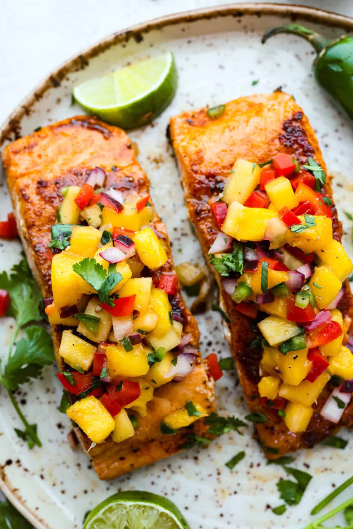 I’m obsessed with salmon, and this Mango Salsa Salmon might just be my new favorite! It’s super flavorful, fast to cook, and somehow my kids don’t fight me on it. That bright, juicy salsa on top? Freaking amazing. I could eat it every night! Overhead shot of mango salsa salmon on a plate.