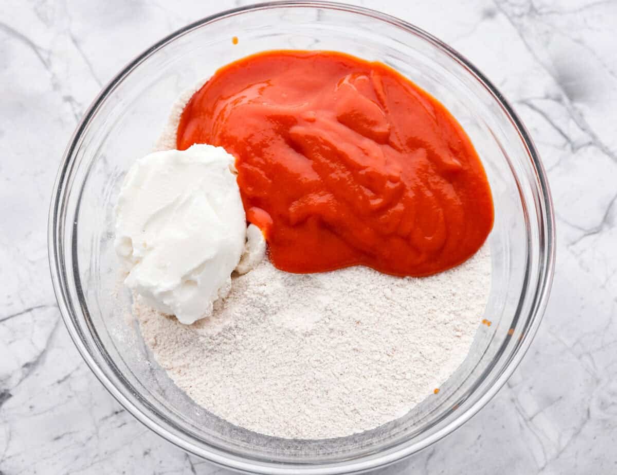 It's time to bring back the retro Tomato Soup Cake! In 1960, it was the first recipe to appear on a soup label. It resembles a moist and delicious spice cake topped with cream cheese frosting. I know you're skeptical, but trust me, it will knock your socks off! Overhead shot of dry ingredients with tomato soup and shortening on top.