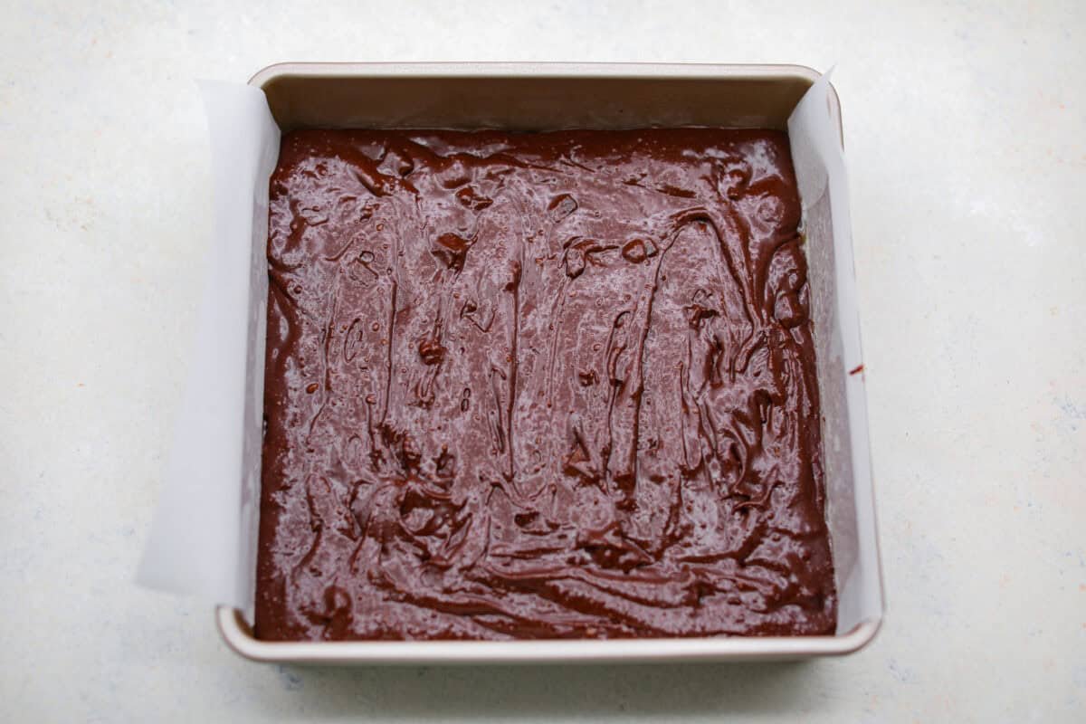 Rich, fudgy, and packed with deep chocolate flavor, Guinness Brownies are a must-try for any dessert lover! The stout beer enhances the cocoa, adding a subtle, malty depth of flavor that makes these brownies rich and irresistibly delicious. Overhead shot of Guinness brownie batter in a baking pan.