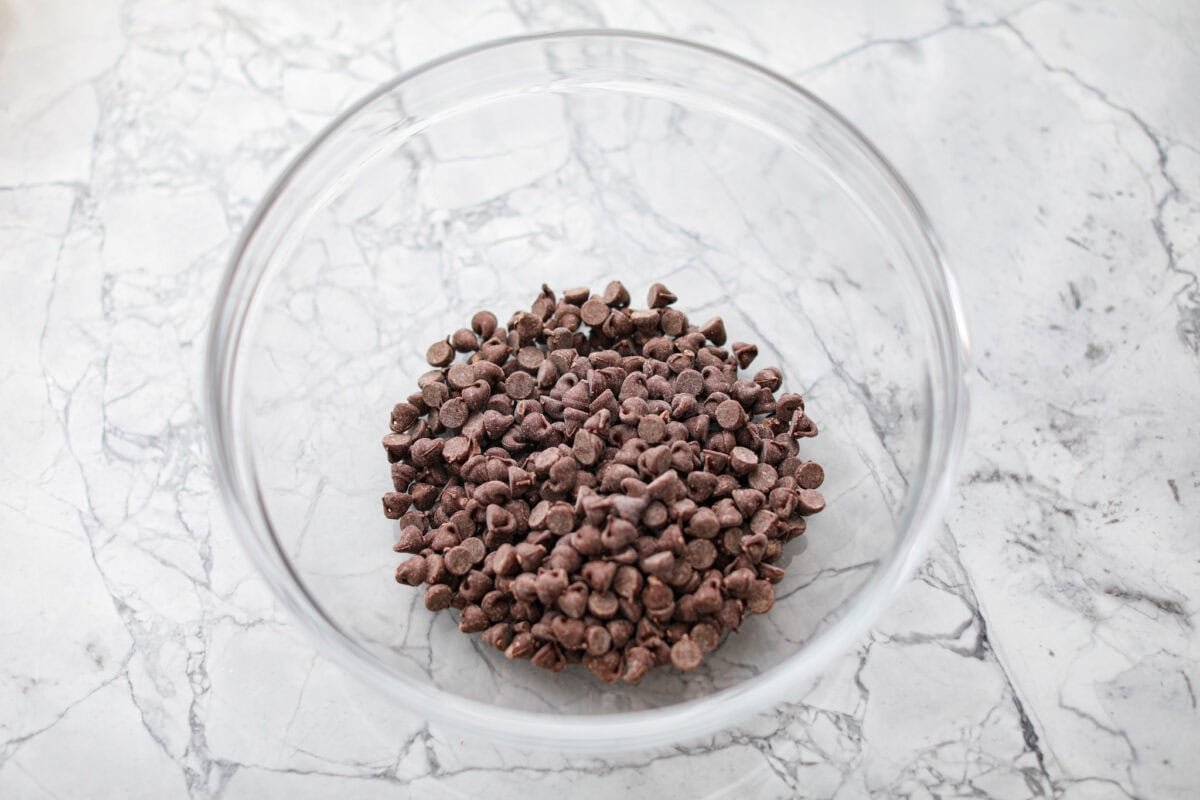Rich, fudgy, and packed with deep chocolate flavor, Guinness Brownies are a must-try for any dessert lover! The stout beer enhances the cocoa, adding a subtle, malty depth of flavor that makes these brownies rich and irresistibly delicious. Overhead shot of chocolate chips in a bowl.