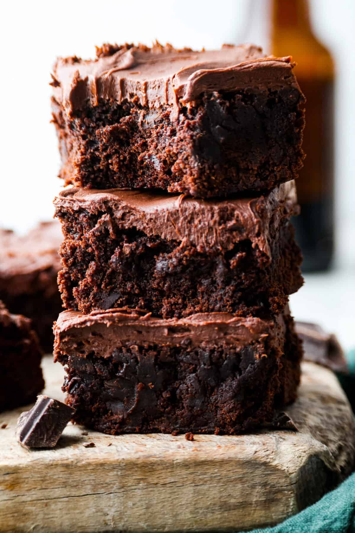 Rich, fudgy, and packed with deep chocolate flavor, Guinness Brownies are a must-try for any dessert lover! The stout beer enhances the cocoa, adding a subtle, malty depth of flavor that makes these brownies rich and irresistibly delicious. Close up shot of a stack of Guinness brownies.
