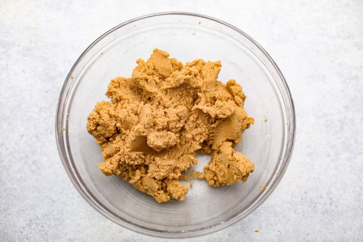 Peanut Butter Blossom Cookies are classic cookies that are perfect for every occasion. The delicious pairing of peanut butter and chocolate in these soft, buttery cookies will delight cookie lovers of all ages. Overhead shot of the wet and ry ingredients mixed together.