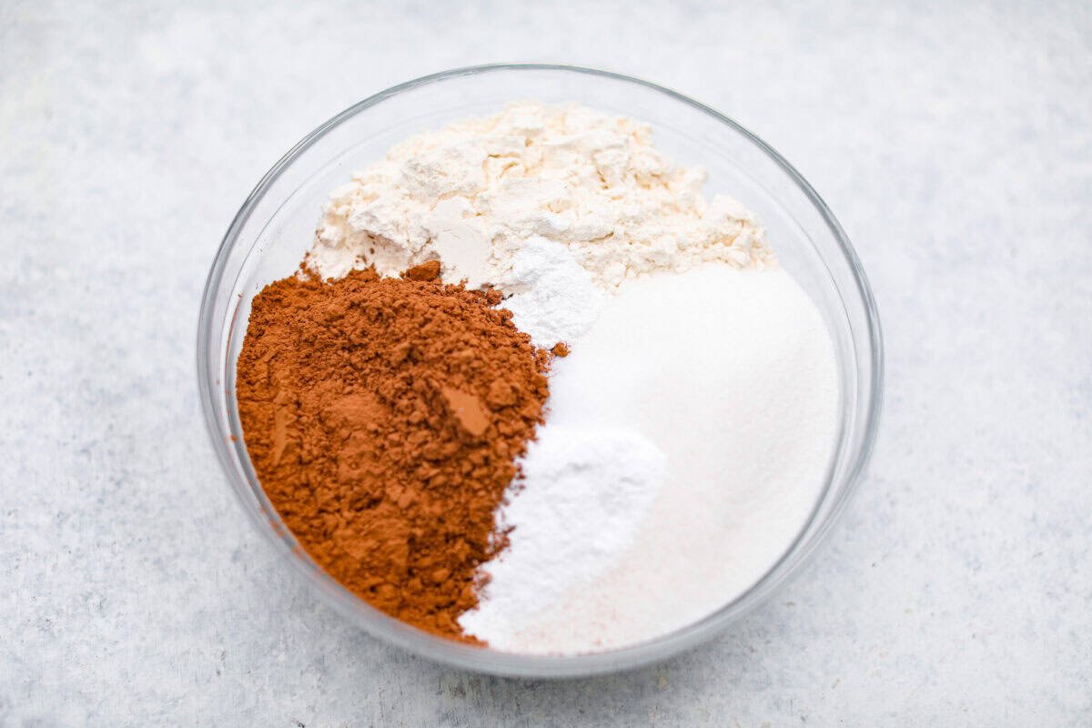 Chocolate Mayonnaise Cake is a rich, moist, and decadent dessert that’s super easy to make! The mayonnaise adds extra moisture and creates a soft, tender crumb. Whether for a special occasion or just because it's sure to impress! Overhead shot of flour, cocoa powder, and sugar in a bowl.