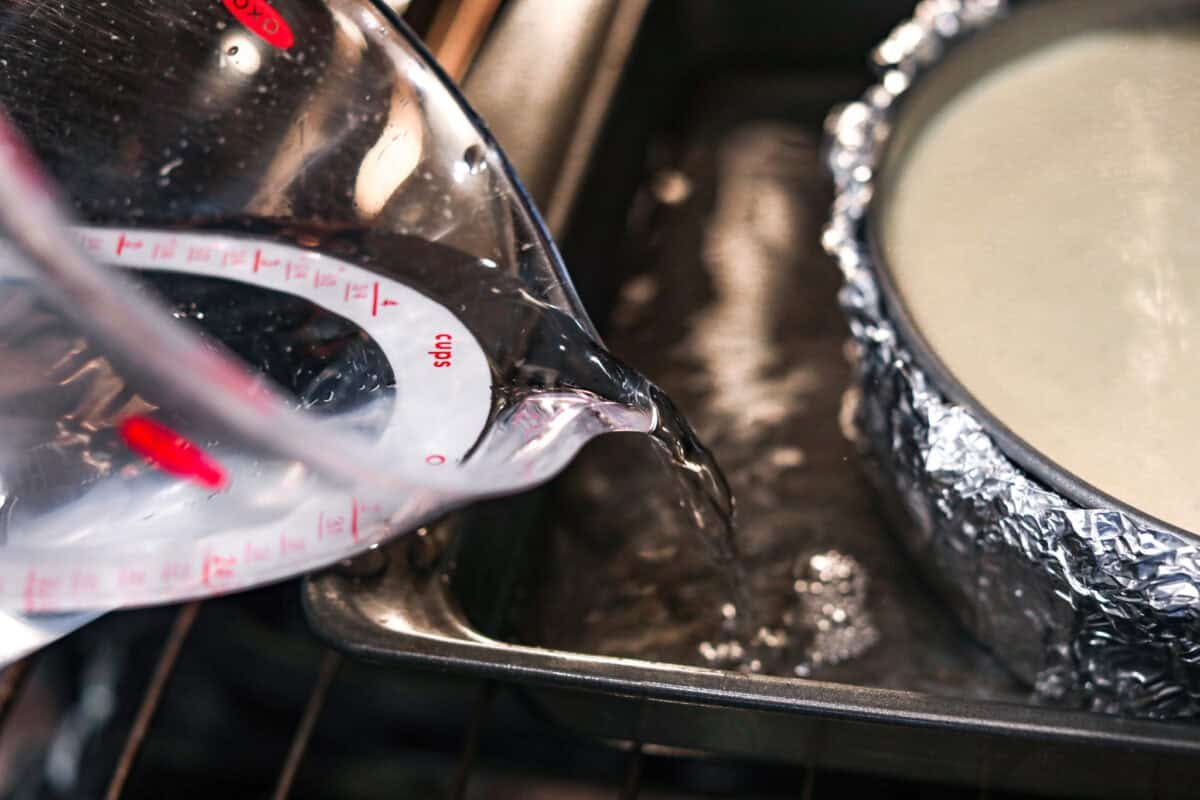 Creme Brulee Cheesecake is the perfect merging of two beloved desserts! It has the rich, creamy texture of cheesecake with the caramelized sugar topping of classic crème brûlée. This irresistible treat is the best of both worlds! Pouring water into a roasting pan.
