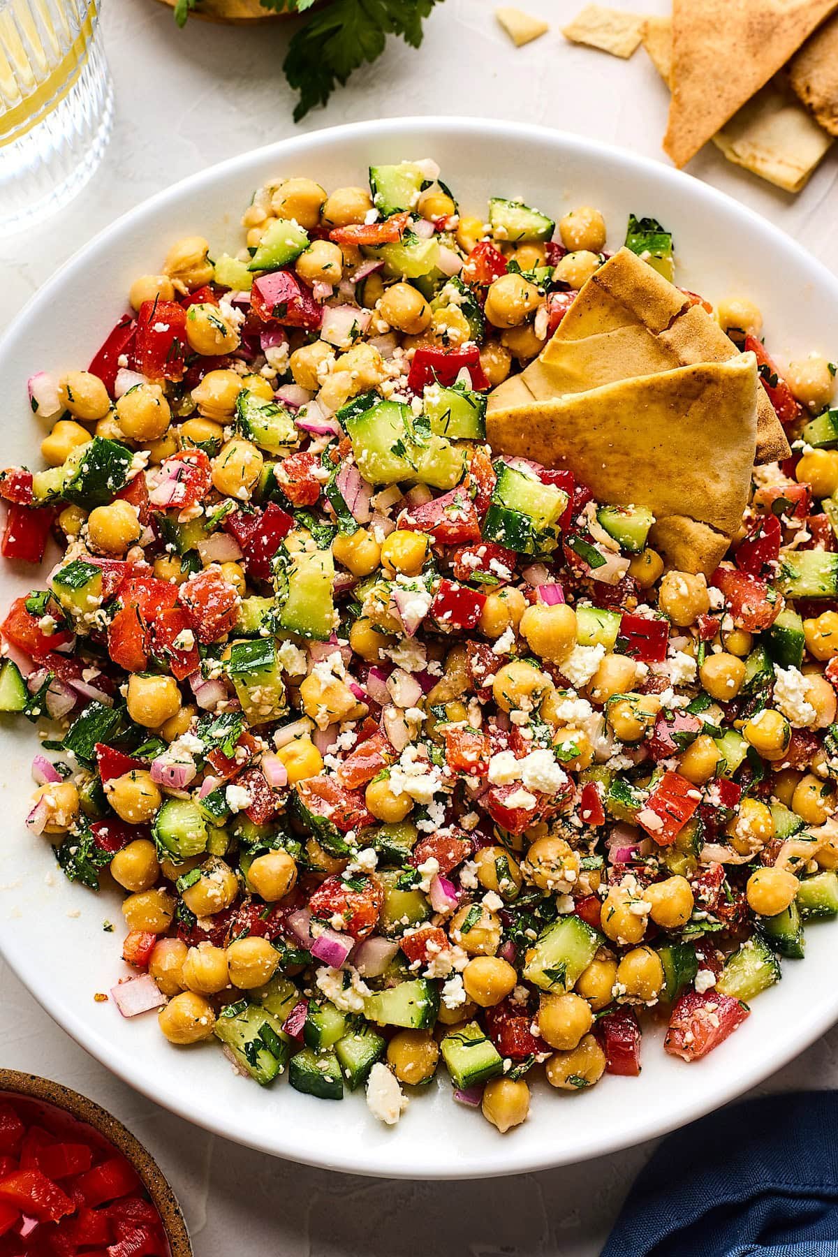 Mediterranean chickpea salad in bowl with pita chips. 