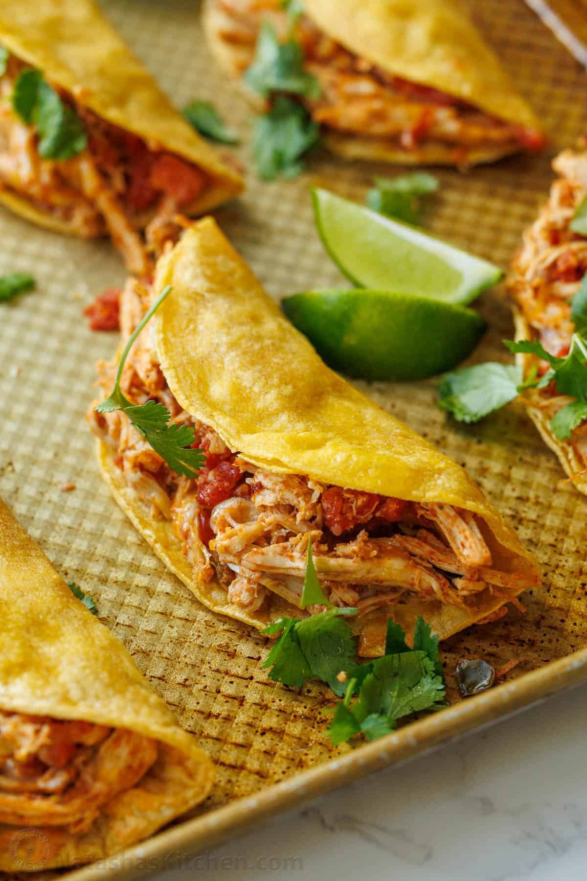Baked Chicken Tacos are a fast and delicious 30-min meal with shredded chicken over cheesy, crisp tortillas - just add your favorite toppings! Baked Chicken taco with corn tortilla ready for storing in the refrigerator or freezer.
