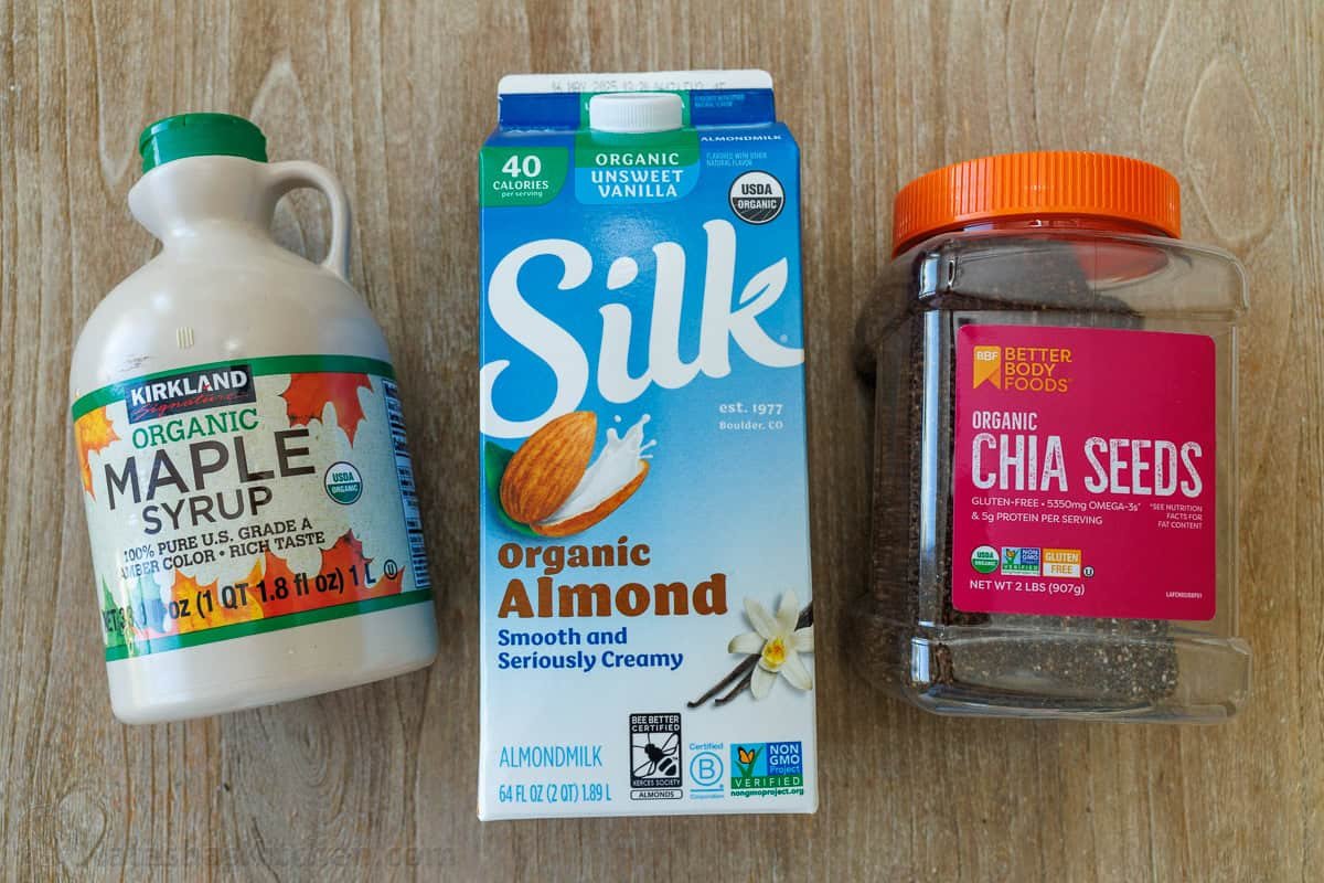 Chia Seed Pudding uses only 3 ingredients to make a delicious and filling breakfast you can prep ahead. Add toppings for the perfect bite. maple syrup, silk almond milk and chia seeds on a wooden table