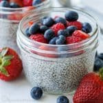 easy chia seed pudding in a small mason jar topped with raspberries and blueberries