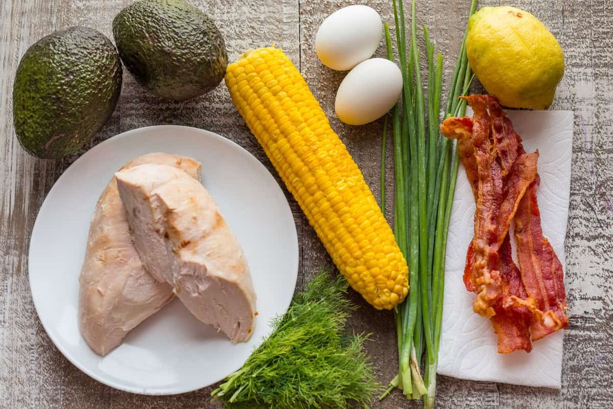 Easy lunch with healthy fats, lean meat, corn, eggs, dill, green onions, bacon and lemon