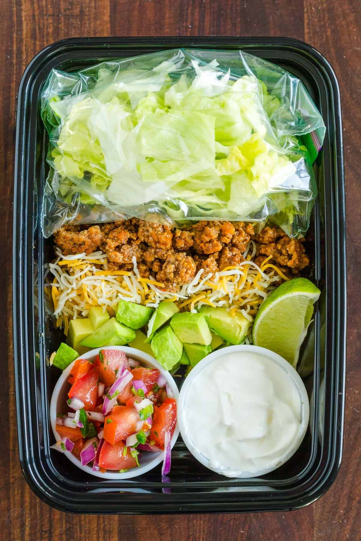 Fresh and easy Taco Salad is loaded with beef, crisp lettuce, veggies, and toppings. Easy 30-minute Taco Salad - perfect for Taco Tuesdays! Taco salad prepped in a to-go container for meal prep