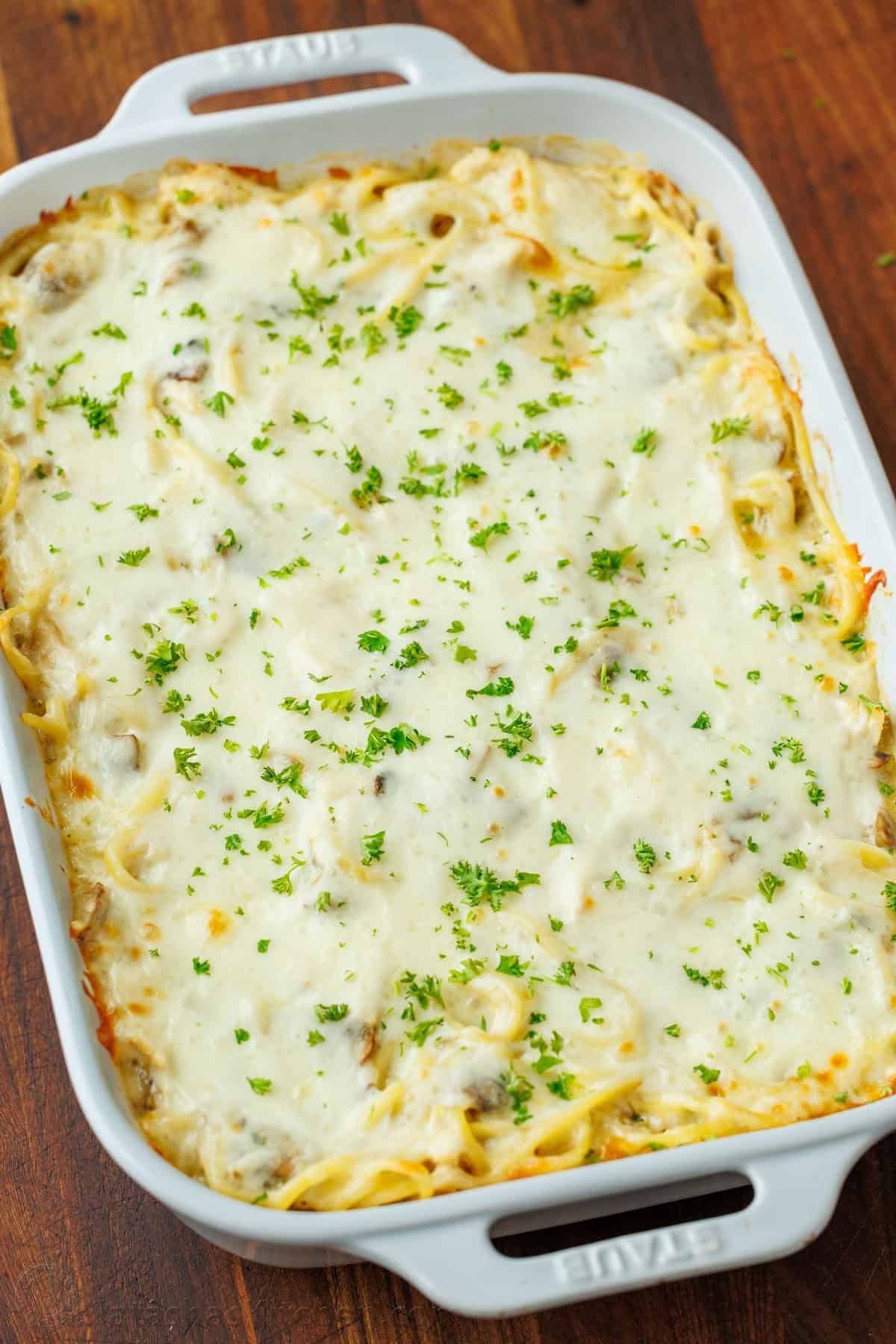 Chicken Tetrazzini is a cheesy, creamy chicken pasta bake that will have your family refilling their bowls! Make this easy casserole today! Chicken tetrazzini recipe in a white casserole dish