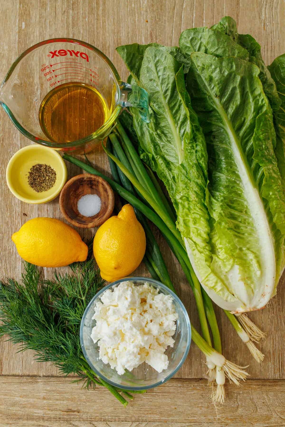 This easy traditional Maroulosalata recipe had crispy lettuce, feta cheese, and fresh herbs for a go-to Greek Lettuce Salad recipe! ingredients for maroulosalata tradtitional Greek lettuce salad including romaine, olive oil, salt, pepper, lemon, feta, green onions, and dill