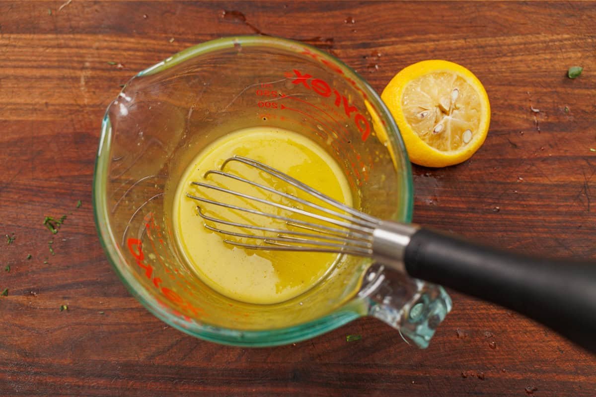 This easy traditional Maroulosalata recipe had crispy lettuce, feta cheese, and fresh herbs for a go-to Greek Lettuce Salad recipe! How to mix Maroulosalata salad dressing in a pyrex measuring cup with a whisk