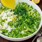 Maroulosalata recipe in a white bowl with dressing drizzled on top