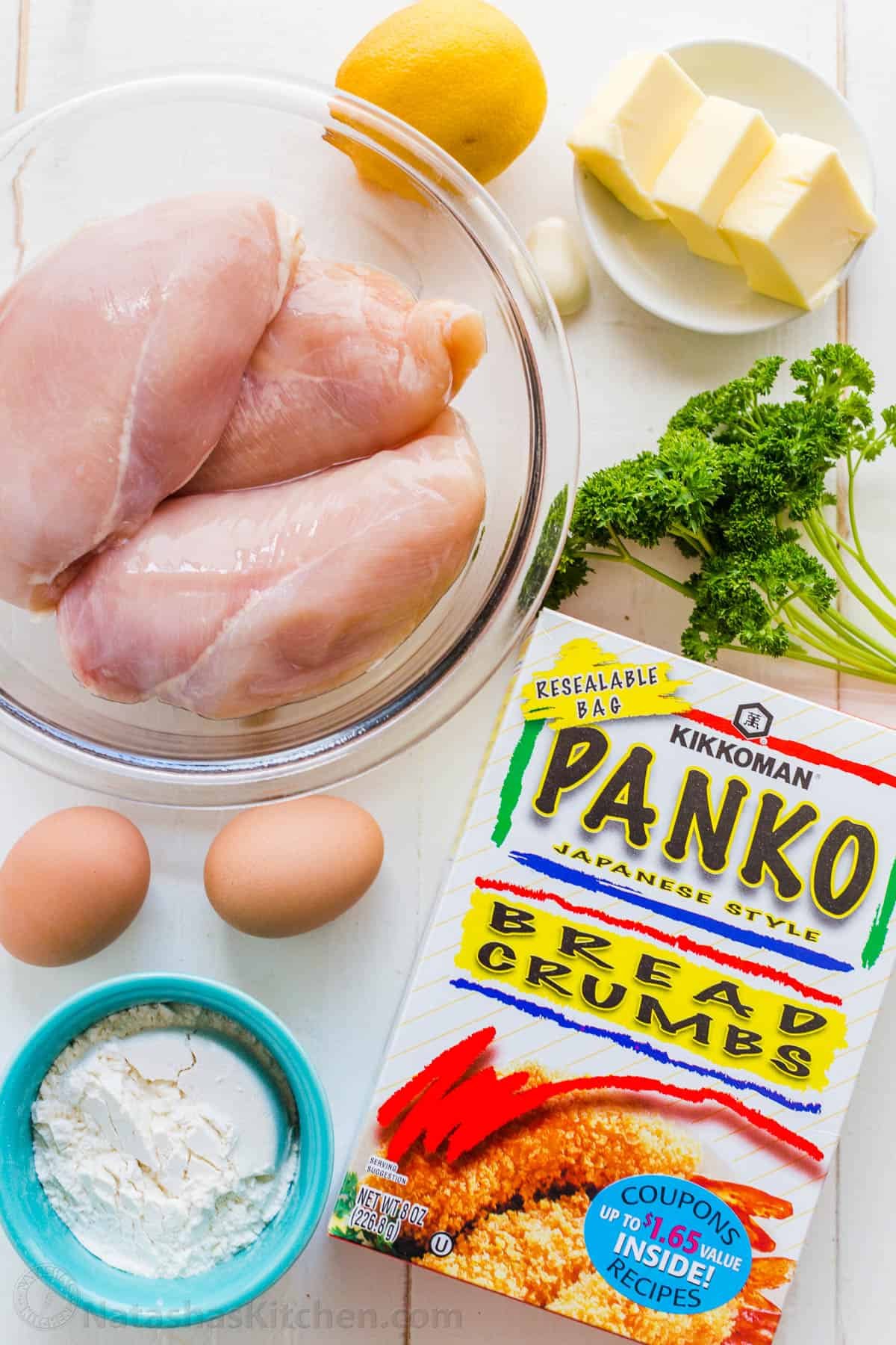 Ingredients for chicken Kiev including chicken breast, lemon, garlic, butter, parsley, panko bread crumbs, egg and flour
