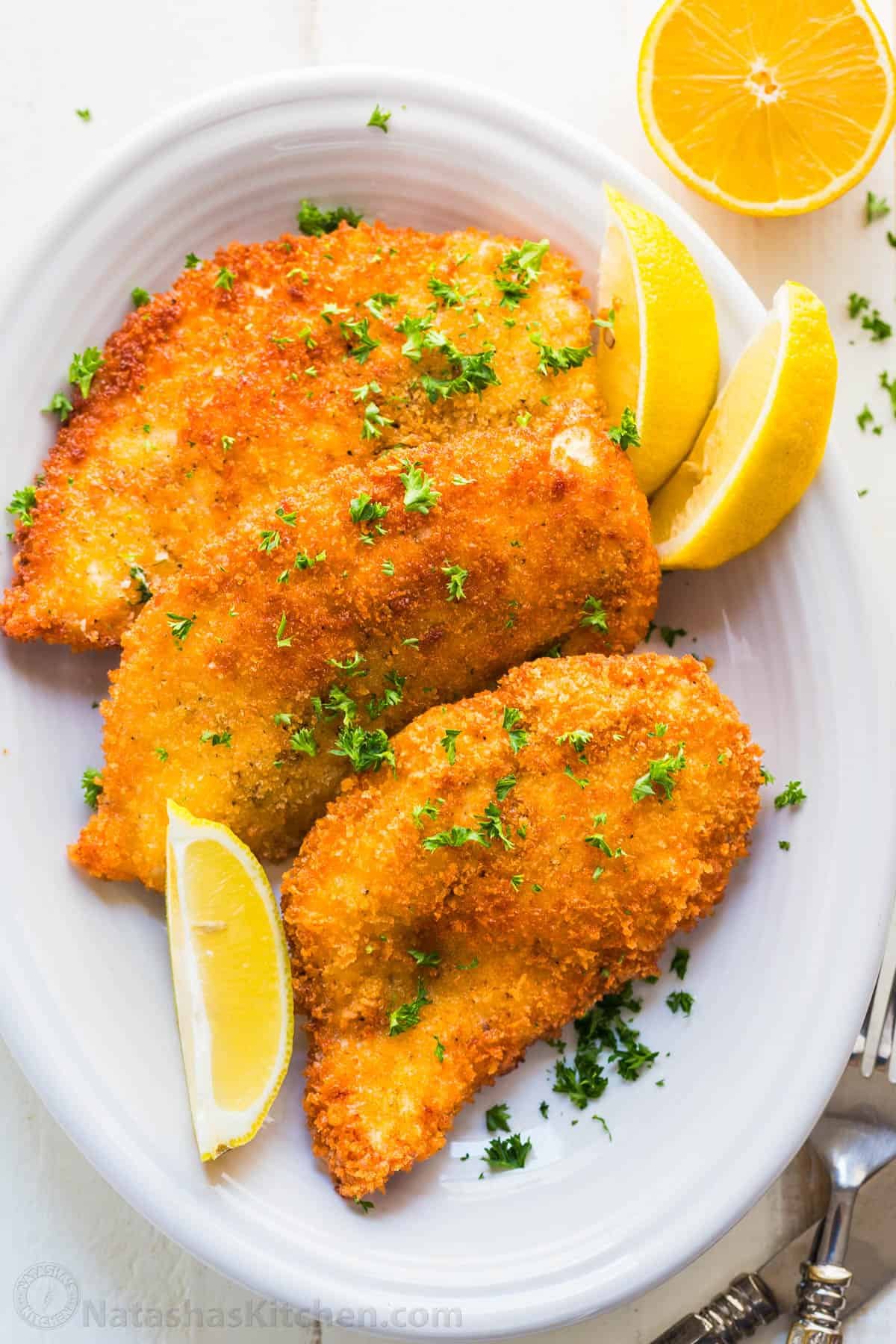 Chicken kiev recipe on a white dish with lemon slices and parsley