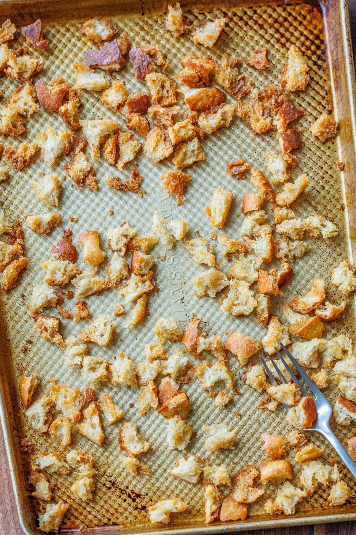 Making Sourdough Croutons is a great way to bring new life to leftover sourdough bread. Use them to bring a delicious crunch to your salads and soups. Crispy golden baked Sourdough Croutons on a baking sheet