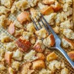 Sourdough croutons on a baking sheet with a fork
