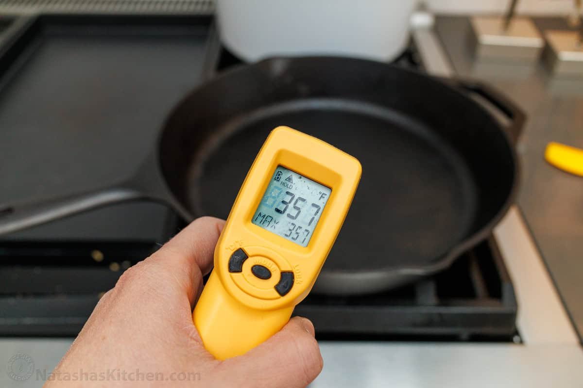 Overnight Sourdough Pancakes are easy! Mix everything before bed, leave at room temp overnight, and wake up to bubbly, ready-to-cook pancake batter. A thermometer reading the cast iron pan's temperature of 357 degrees.