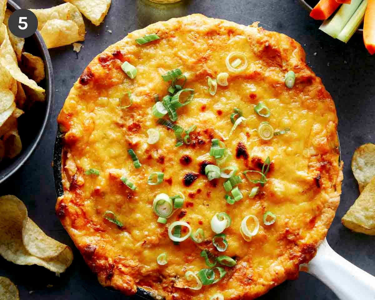Buffalo Chicken Dip in a skillet with green onions on top.