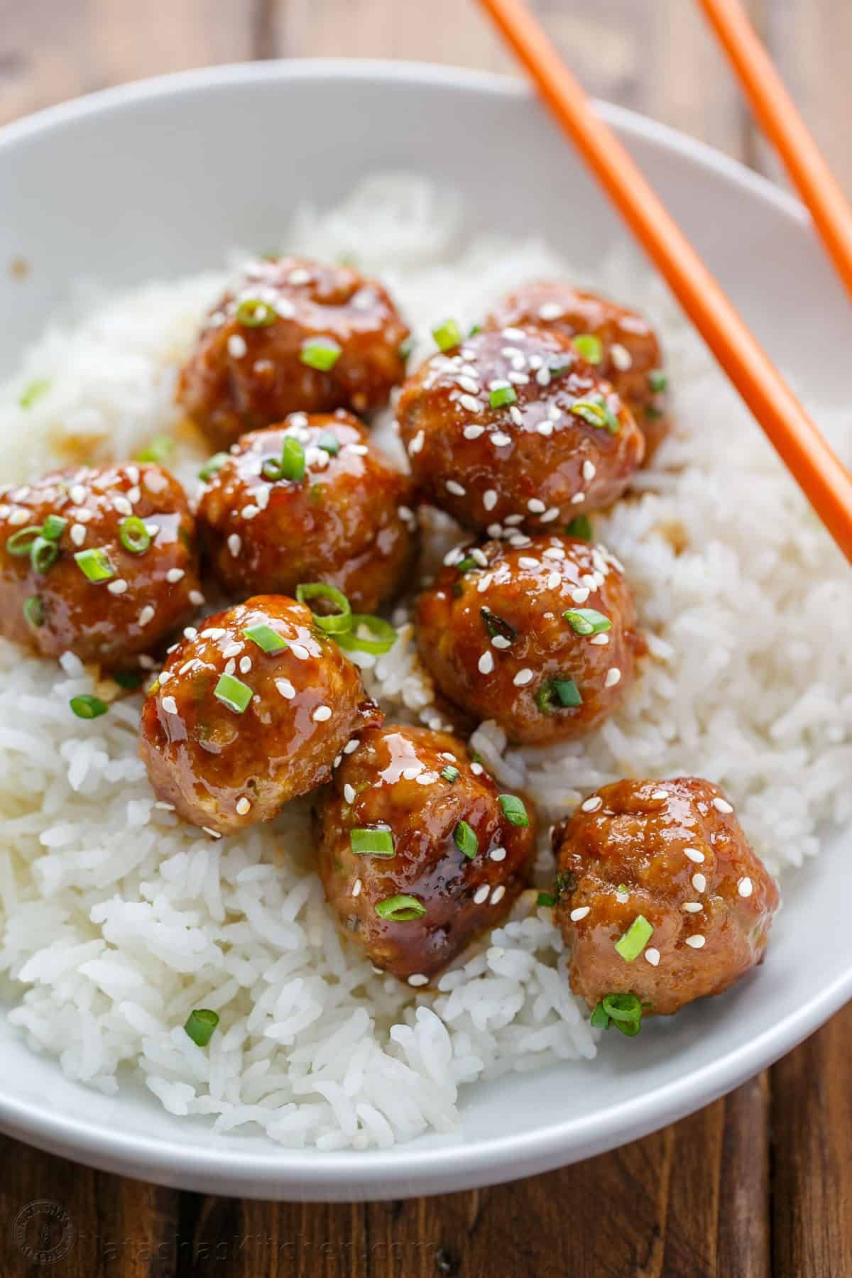 30-minute Turkey Teriyaki Meatballs are just as juicy with less guilt! Simply bake the meatballs and cover them with homemade teriyaki glaze. Homemade Turkey meatballs served on top of rice in a white bowl with chop sticks