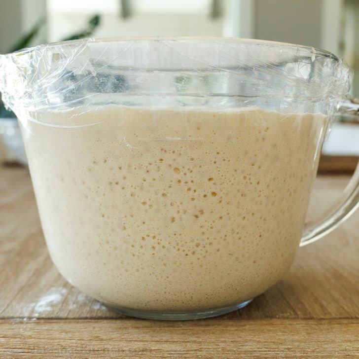 Sourdough Pancakes are a delightful twist on the classic breakfast favorite, with a soft and spongy texture and great sourdough flavor. Sourdough pancake batter in a glass measuring bowl, showing the fermentation process with bubbles, doubled in size.