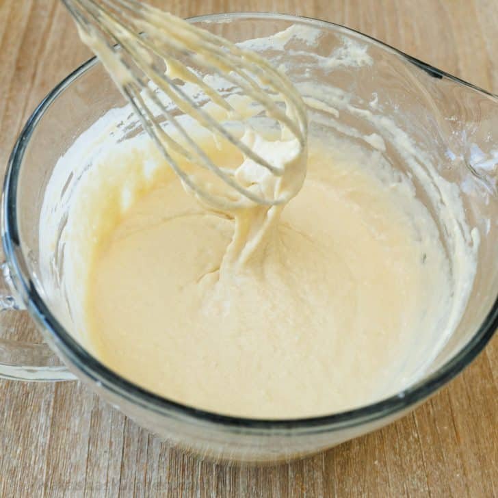 Sourdough Pancakes are a delightful twist on the classic breakfast favorite, with a soft and spongy texture and great sourdough flavor. Whisking sourdough pancake batter in glass bowl until smooth in consistency.