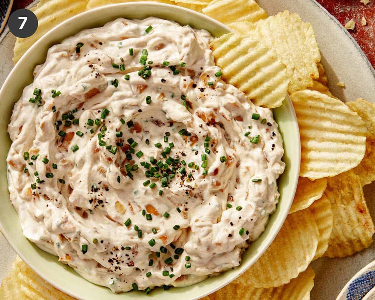 French onion dip in a bowl with chips on the side.