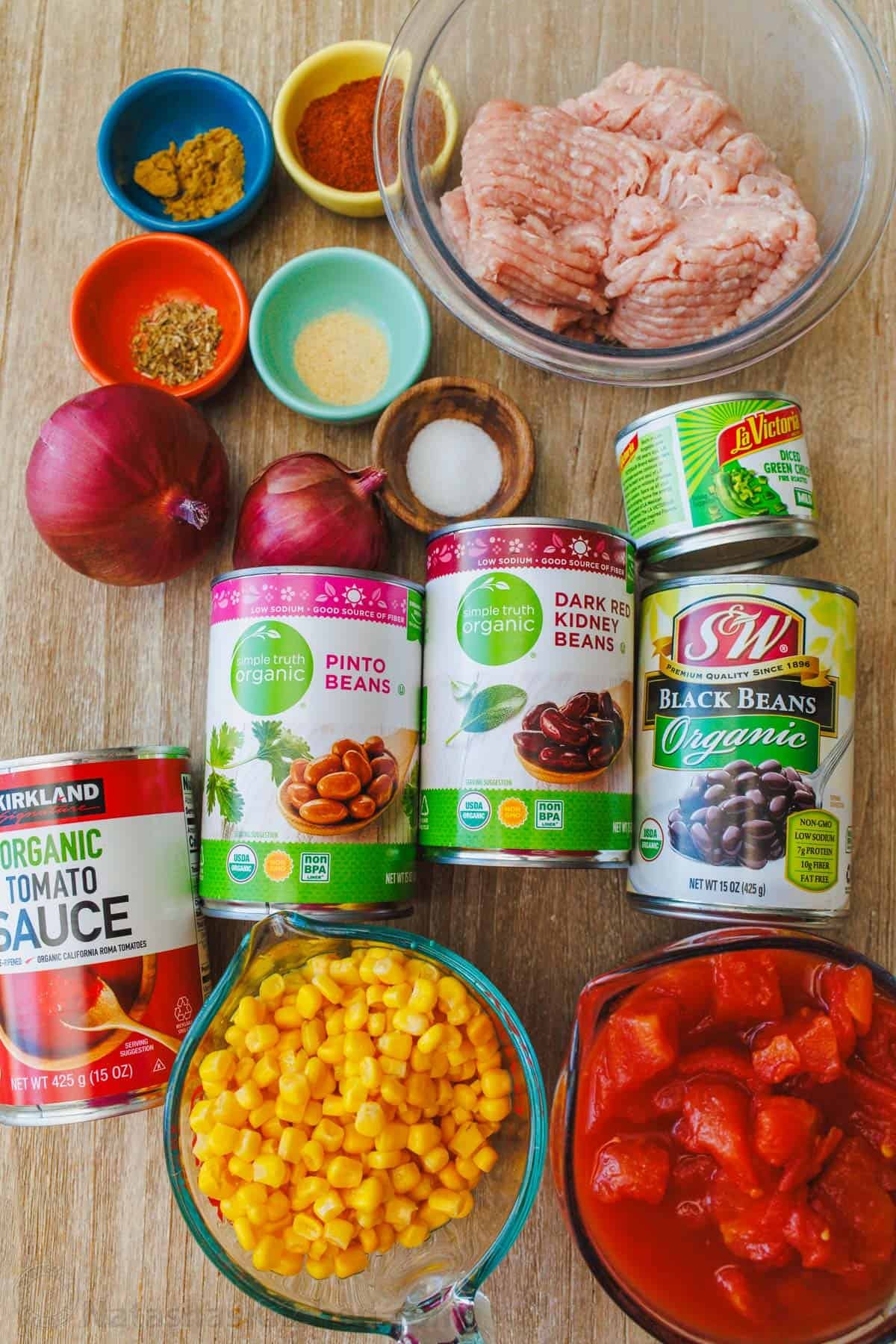 My turkey chili recipe is so easy to make in 40 minutes on the stovetop or slow cooker. Ground turkey, beans and veggies make it a favorite! ingredients for turkey chili recipe including ground turkey, red onion, chili powder, cumin, garlic powder, oregano, salt, pepper, diced tomatoes, tomato sauce, black beans, kidney beans, pinto beans, green chilis, and corn