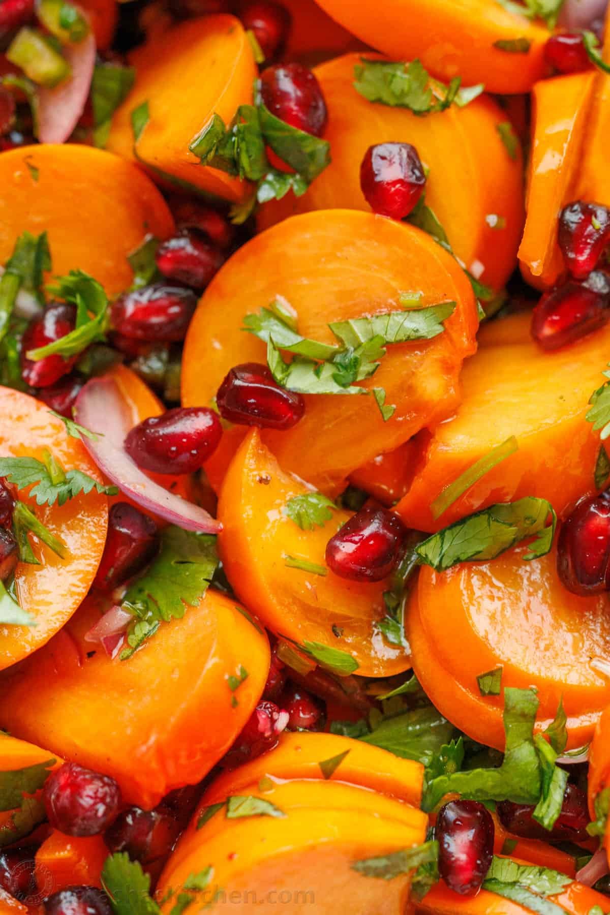 This easy persimmon pomegranate salad with lime cilantro dressing is one of the most exciting salads I've tried. It's vibrant and memorable! Close up photo of Cilantro Lime dressing on Persimmon Pomegranate Salad