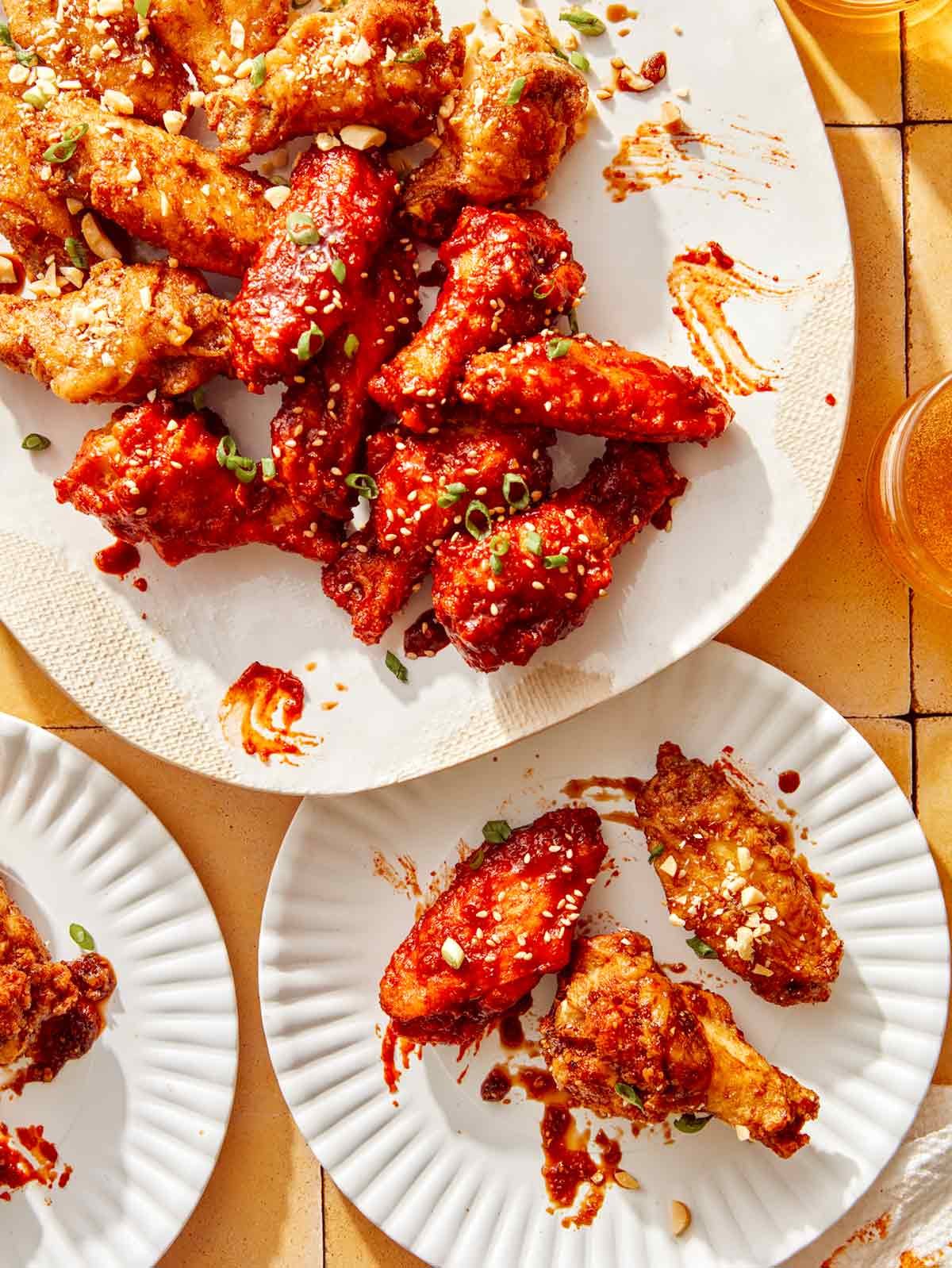 Korean fried chicken on a platter with some on served onto a plate.