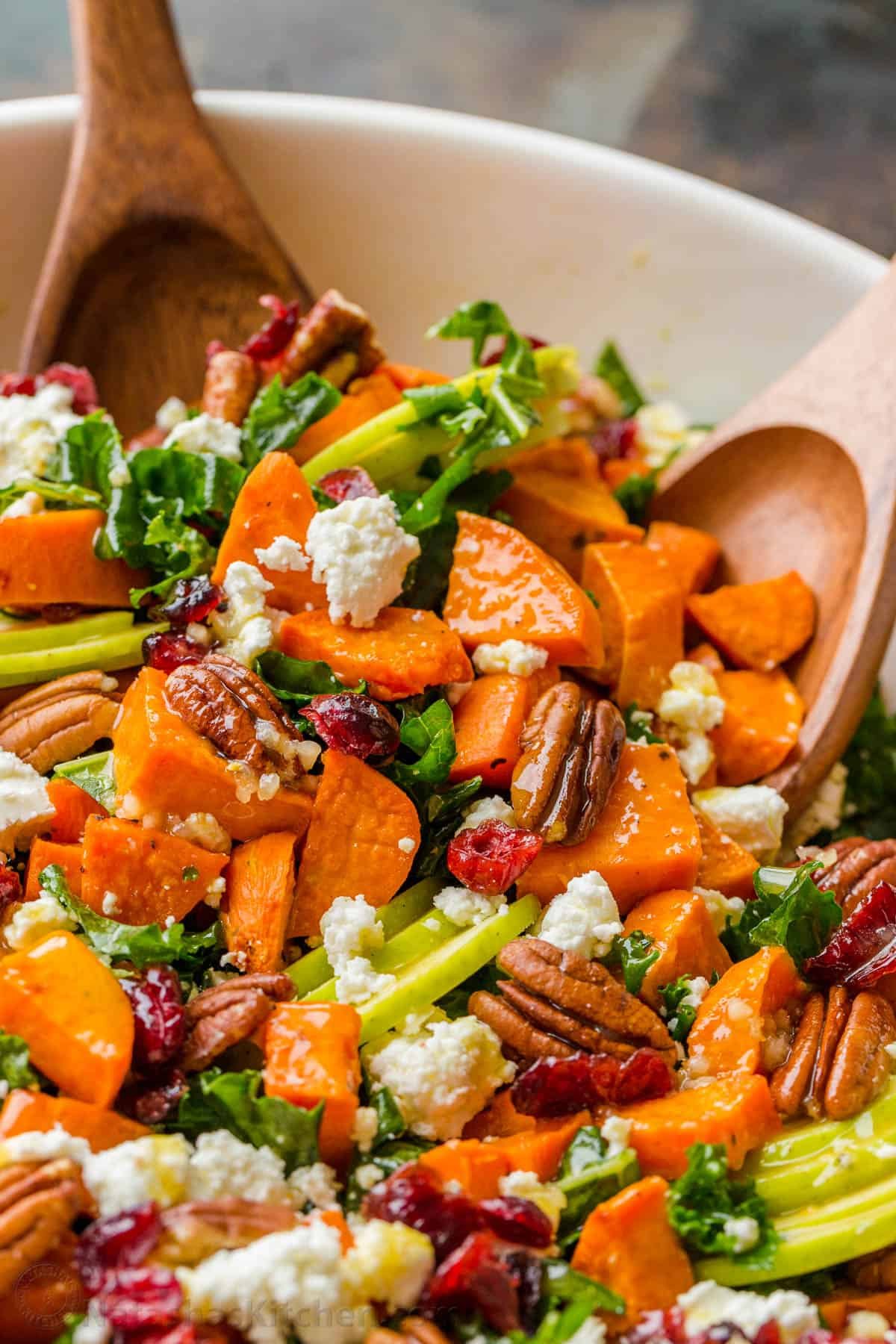 Roasted Sweet Potato Salad has all the best Fall flavors. Loaded with kale, sweet potato, apple, pecans, goat cheese, and the best dressing. Tossing sweet potato salad with salad servers