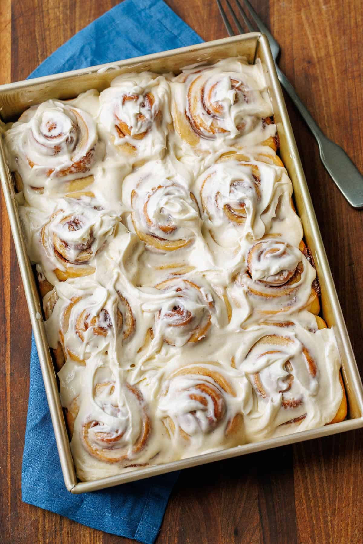 The perfect recipe for soft, fluffy, and buttery Sourdough Cinnamon Rolls, layered with cinnamon sugar and topped with creamy cream cheese frosting. Baked Sourdough Cinnamon Rolls in a metal pan, smothered with the best Cream Cheese frosting.