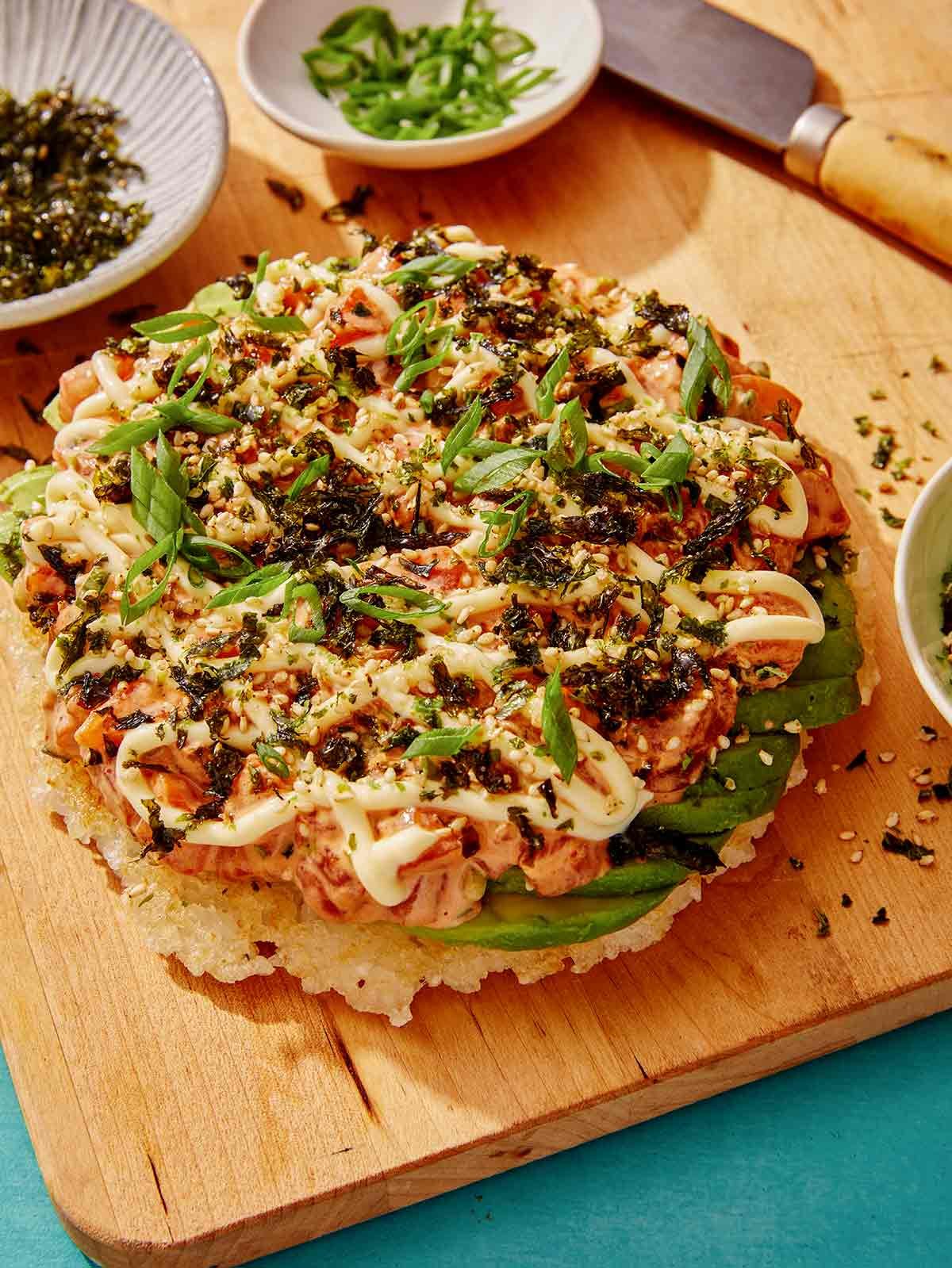 Sushi pizza on a cutting board. 